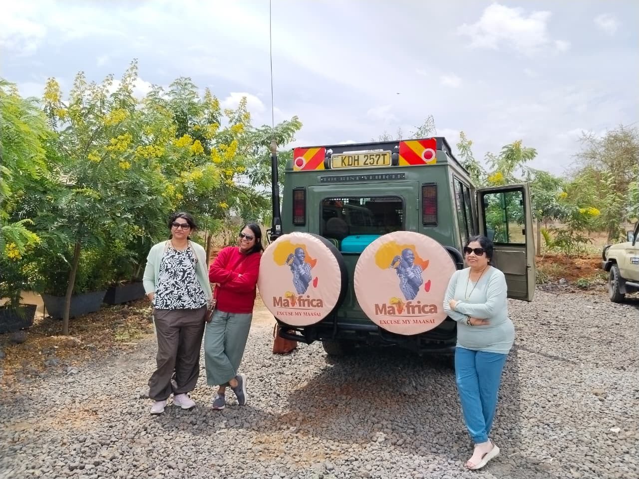 Guests beside their safari vehicle before a Maasai Mara game drive
